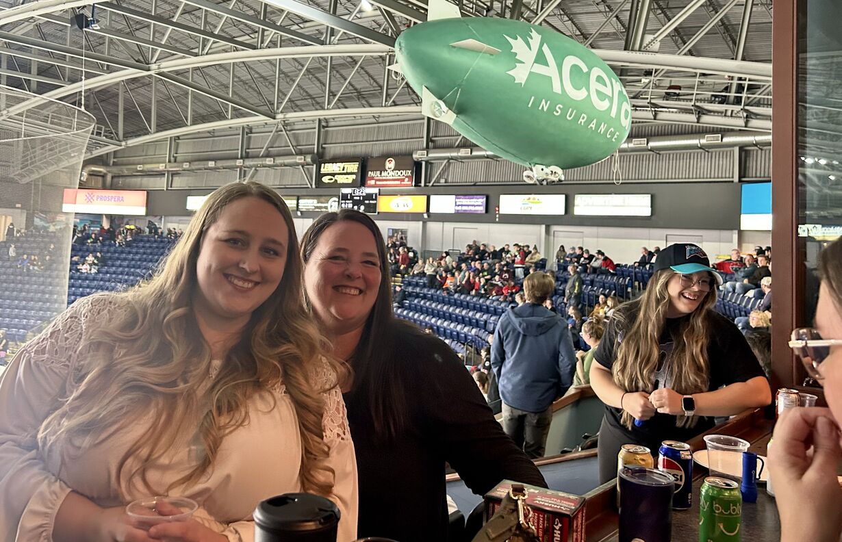 Our Kelowna office team, all smiles above the ice at Prospera Place.